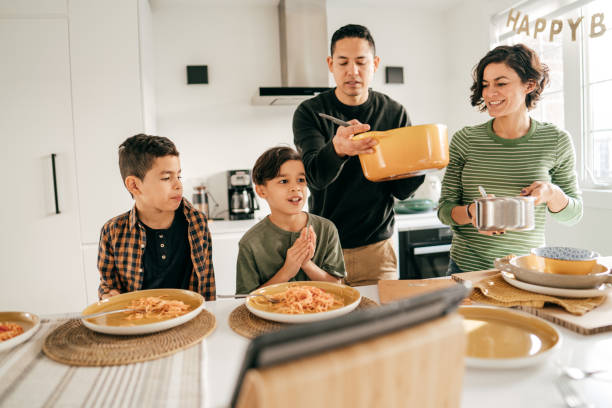 istock Dad serving lunch, kids are praying. 1295846249