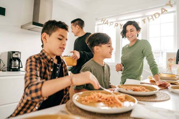 Family Mortgage Planners Family having online lunch with online friends kids eating noodles stock pictures, royalty-free photos & images