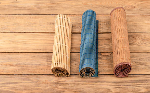 istock Three rolled up bamboo mats on a wooden background. 1295846528