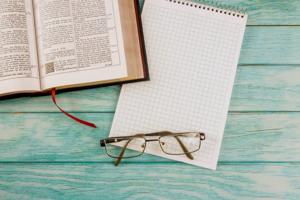 istock Opened the Holy Bible close up prayer time in eyeglasses on notepad 1295848612