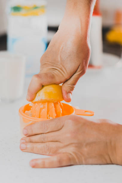istock Squeeze lemon by hand with lemon juicer in kitchen 1295848699