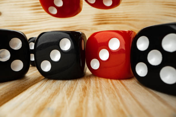 istock Red and black dice cubes on wooden background 1295849052