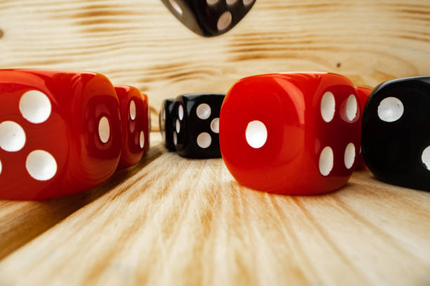 istock Red and black dice cubes on wooden background 1295850003