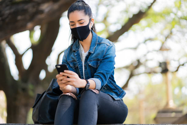 istock Young woman using her mobile phone outdoors. 1295850371