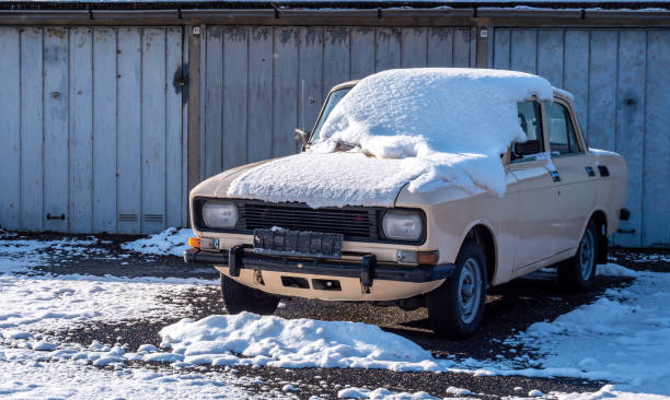 old broken vintage red rusty retro car parked in winter on snow background on frosty winter day