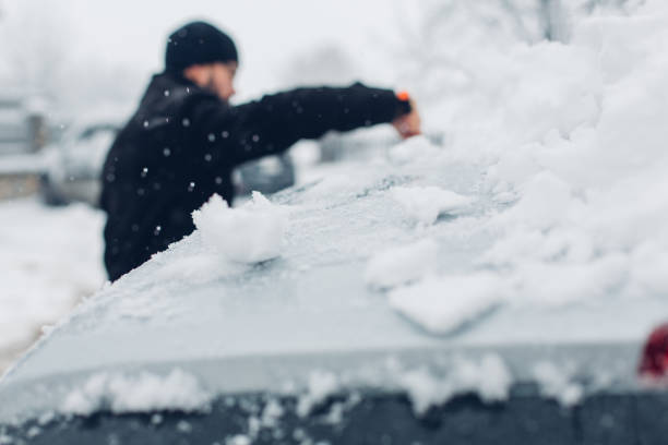 istock Cleaning Snow From Car 1295852391