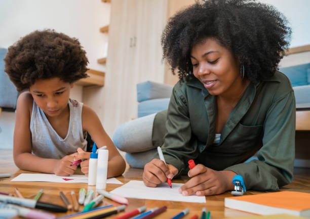 istock Mother and son drawing with colored pencils on floor. 1295852521