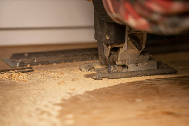 istock Wood processing. Person cutting wooden board with electric jigsaw 1295852535