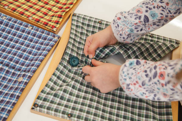Girl buttoning a montessori dressing frame to develop the dexterity of her fingers.