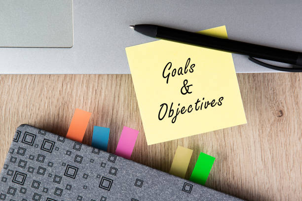 istock Goals and Objectives words written on note. Diary, pen and laptop. 1295853470