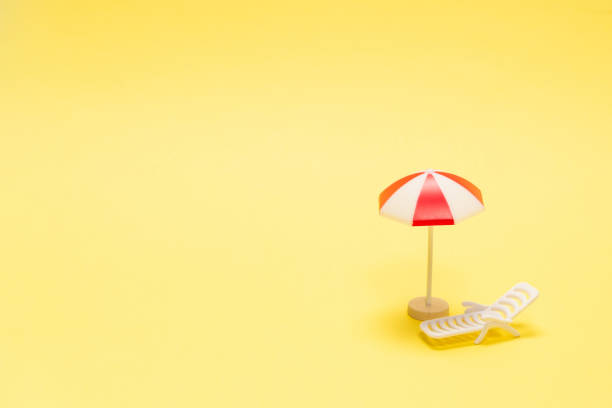 istock Two sun loungers and a red umbrella on a yellow background. 1295853724