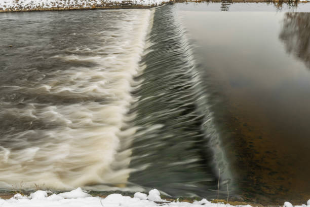 Winter view for Malse river and weir in snowy cold cloudy gray day