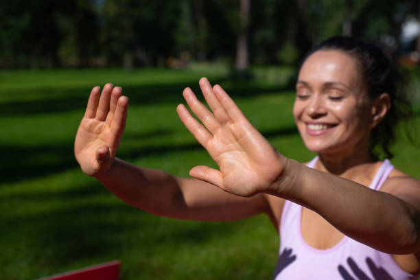 istock Selective focus on a woman smiling while taking sunbathing and enjoying sunny day in the park 1295855904