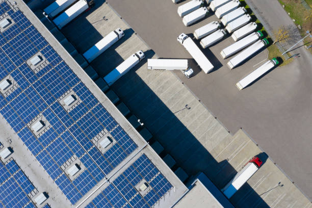 vista aérea de contêineres de carga e armazém de distribuição com usinas de energia renovável - truck parking horizontal shipping - fotografias e filmes do acervo