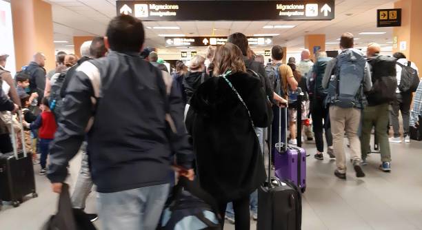 menschen, die nach der ankunft am flughafen lima, peru, südamerika auf passkontrolle warten - customs official examining emigration and immigration document stock-fotos und bilder