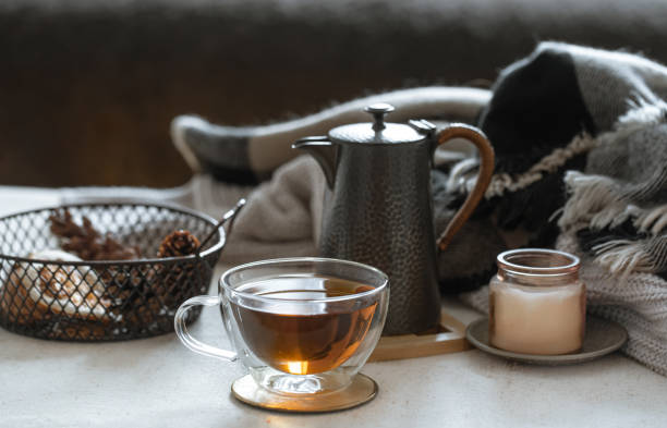 istock Cozy home composition with a cup of tea, kettle and candlestick close up. 1295857329