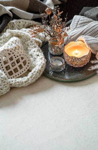 istock Cozy home composition with a burning candle and knitted elements. 1295857344