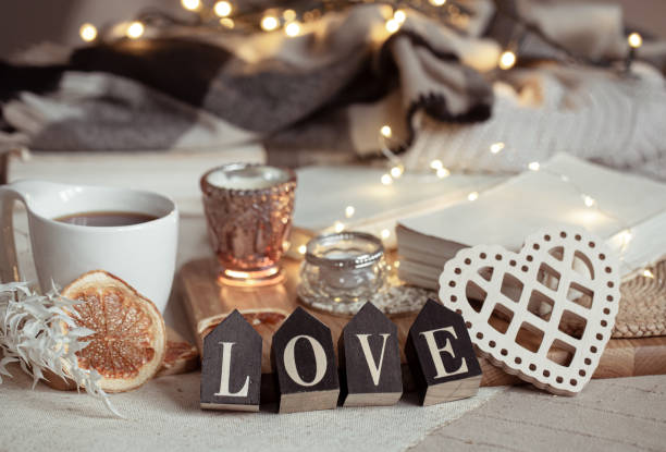istock Cozy home composition with decorative word love on blurred background with bokeh. 1295857963