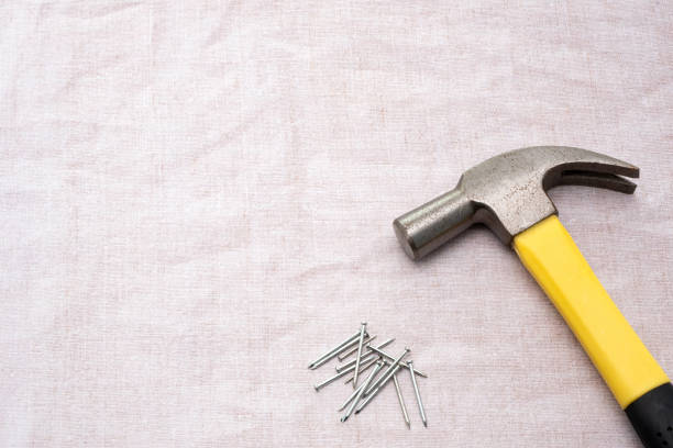 Small nails and carpenter hammer on a wooden worktable. Handmade master. Small carpentry work in the workshop. Home renovation