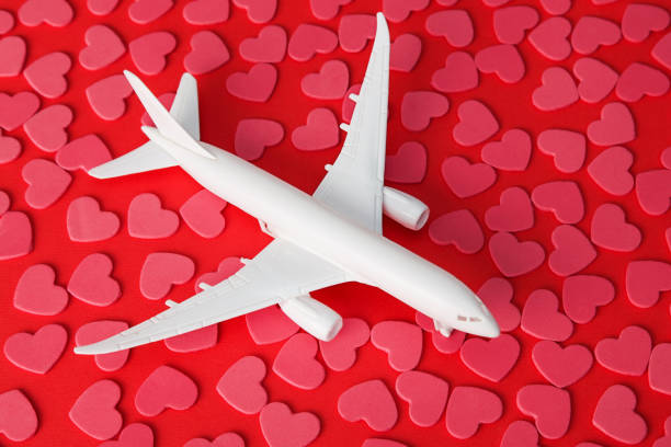 istock Plane and hearts on red background. Customer support and customer service concept. Love for clients. Valentines Day concept 1295858307