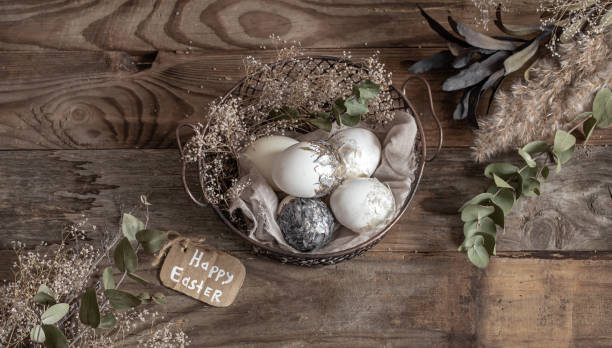 istock Easter composition with decorative eggs in a basket on a wooden surface. 1295858336
