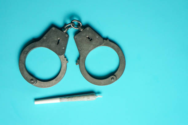 istock a joint of marijuana and handcuffs on a blue background 1295859383
