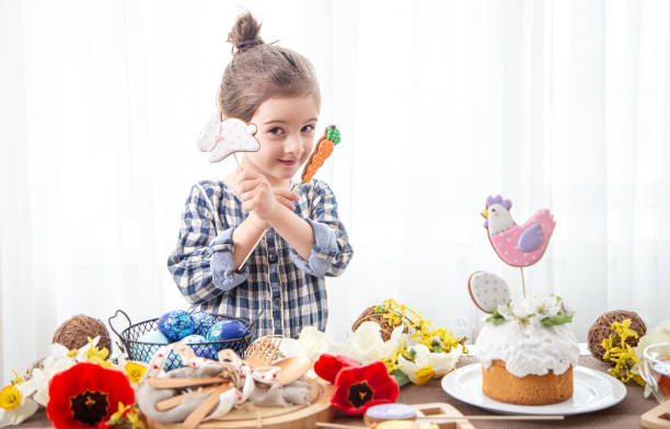 A cute little girl decorates a festive cake for the Easter holiday copy space.