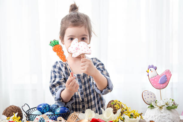 istock Cute little girl holding easter cookies on sticks. 1295859399