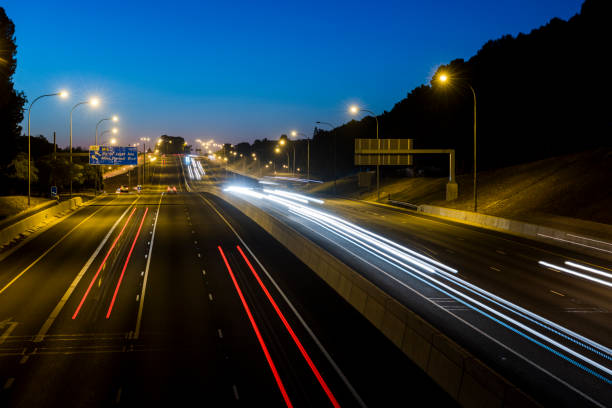 istock Multi lane highway at night with cars moving 1295860389