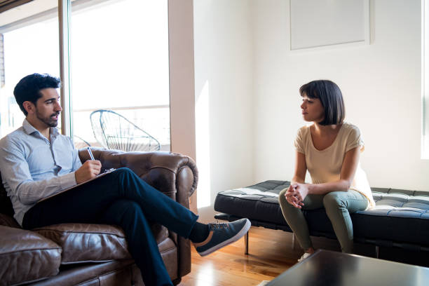 istock Psychologist talking with patient on therapy session. 1295860904