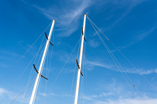 Horizontal view of sailing boat masts against sky background