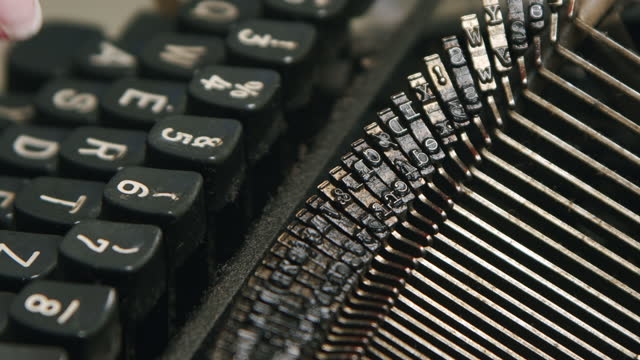 Hands writing on a vintage typewriter. Metal parts of old typewriters