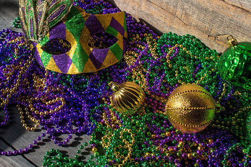 Mardi Gras decorations with pile of beads, mask, and ornaments
