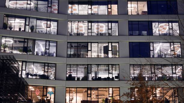 istock Pattern of office buildings windows illuminated at night. 1295866363