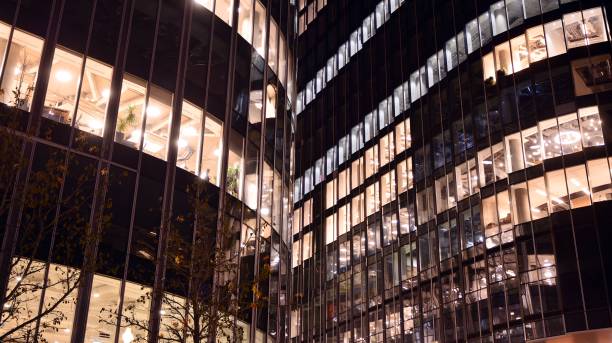 istock Pattern of office buildings windows illuminated at night. 1295866705