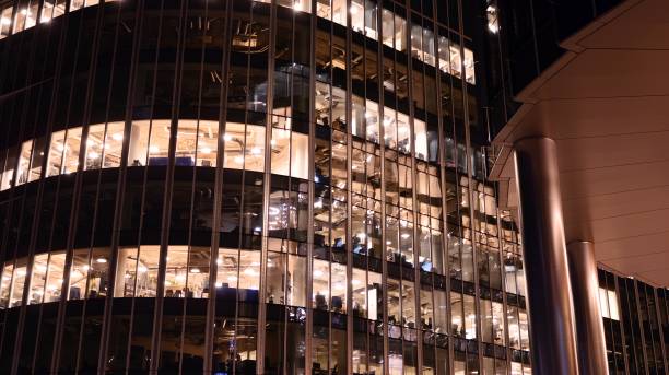 istock Pattern of office buildings windows illuminated at night. 1295866754