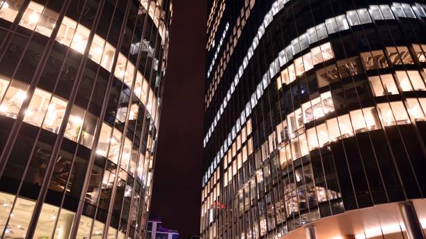 istock Pattern of office buildings windows illuminated at night. 1295867479