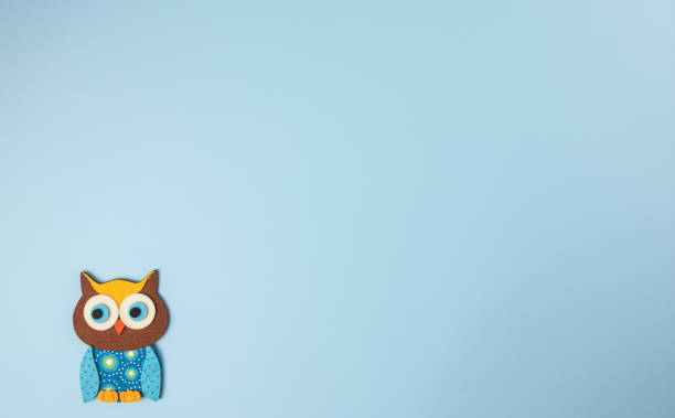 istock Little owl isolated on blue background 1295867699