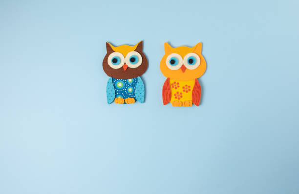istock Two little owls isolated on blue background 1295867762