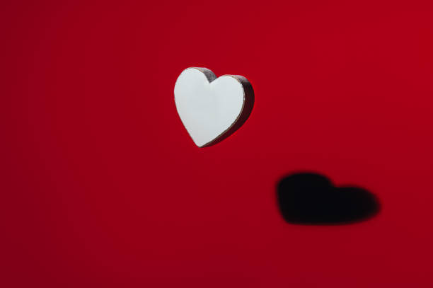 istock White wooden heart with strong shadow 1295868069