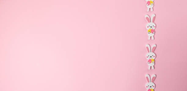 istock Wooden easter rabbits isolated on pink background 1295869816