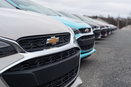 Dartmouth, Canada - January 10, 2021 - A long line of 2021 Chevrolet Spark hatchbacks at a dealership.