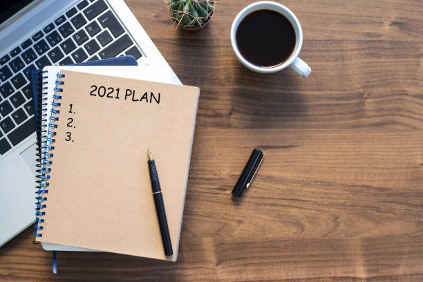 istock Note book with 2021 goals text on it to apply new year resolutions and plan. 1295872099