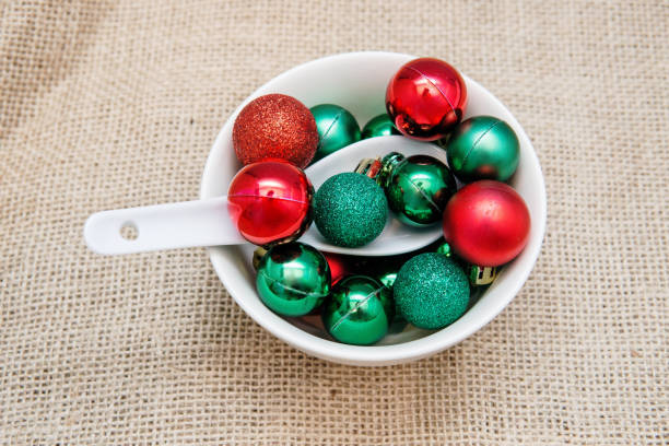 istock Red and green Christmas baubles in white bowl with spoon. 1295872261
