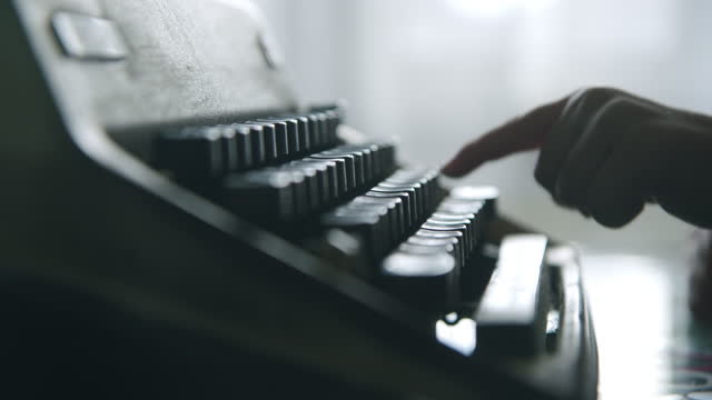 Hands writing on a vintage typewriter