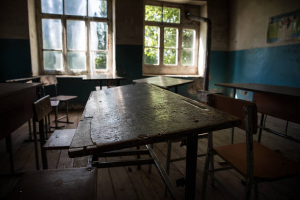 istock Old and abandoned school classroom interior, in black and white. 1295875252