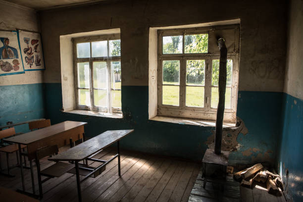 istock Old and abandoned school classroom interior, in black and white. 1295875259