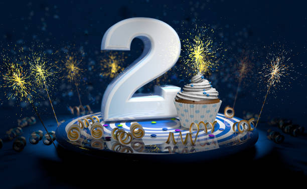 istock 2th birthday or anniversary cupcake with big white number with yellow streamers on blue table with dark background full of sparks. 3d illustration 1295877009