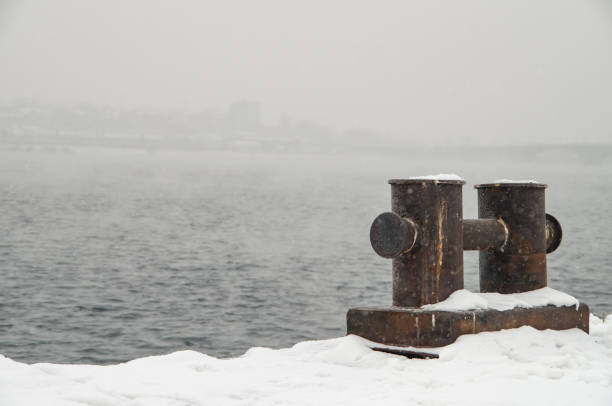 Rusted bollard on a snowy pier Rusted bollard on a snowy pier bollard pier water lake stock pictures, royalty-free photos & images