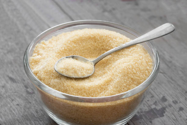 istock Sugar in glass bowl with metal spoon on table. 1295877407